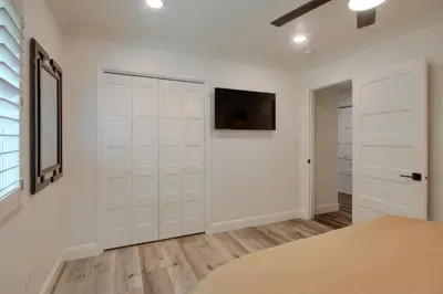 a white closet with white doors and a television at Doe Cabin Hot Tub/Playground/Game Room and more in Oakhurst