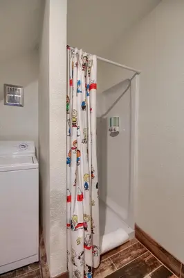 a shower with a shower curtain in a bathroom at Doe Cabin Hot Tub/Playground/Game Room and more in Oakhurst