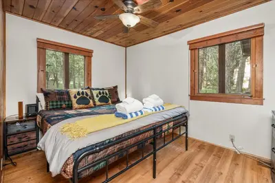 a bedroom with a bed and a ceiling fan at Cub House- Remodeled cabin INSIDE Yosemite with new hot tub and more in North Wawona