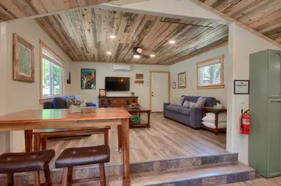 a living room with a table and a couch at Beetlebark Bungalow- Inside Yosemite w/ hot tub EV charging cable in North Wawona