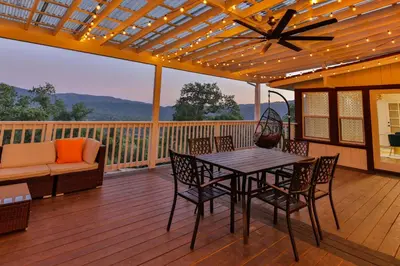 a patio with a table and chairs on a deck at Canyon View House w/ hot tub, game room, views, and more in Oakhurst
