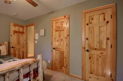 a bedroom with a bed and two wooden doors at Hibernation Hideaway- Inside Yosemite- Dog Friendly in South Wawona
