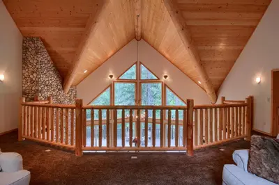 a large room with a large window and wooden ceilings at Rivercrest Lodge with Hot Tub-Pool Table-Firepit in North Wawona