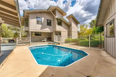 a house with a swimming pool in front of a house at Hodges Hill Hideout w/ pool, spa, BBQ - Dog Friendly in Oakhurst