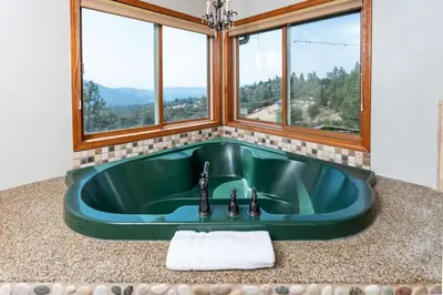 a green sink in a bathroom with windows at Skyline Lodge- amazing views w/spa/game room in Oakhurst