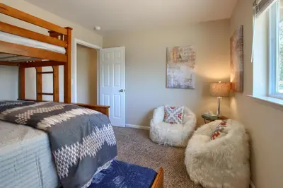 a bedroom with a bed and two chairs at Scenic Serenity 50 acres/hot tub/game room in Oakhurst
