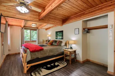 a bedroom with a bed and a wooden ceiling at 3 Springs Hideout - Family cabin with hot tub in Yosemite in South Wawona