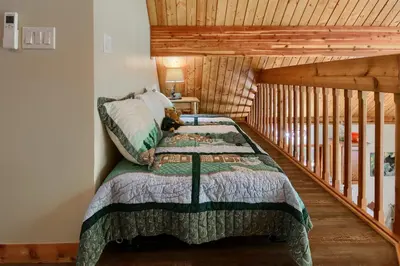 a bedroom with a bed in a log cabin at 3 Springs Hideout - Family cabin with hot tub in Yosemite in South Wawona