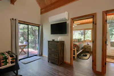 a living room with a television and a bedroom at 3 Springs Hideout - Family cabin with hot tub in Yosemite in South Wawona