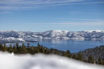 a view of a lake with snow covered mountains at Taste of Burgundy condo in Incline Village