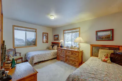 a bedroom with two beds and a dresser and two windows at Tahoe Donner Greenbelt Retreat in Truckee