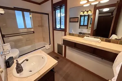 a bathroom with a sink and a toilet and a mirror at Brookstone Pines home in Incline Village