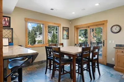 a kitchen with a table and chairs and a clock on the wall at Stage Coach Run home in Stateline