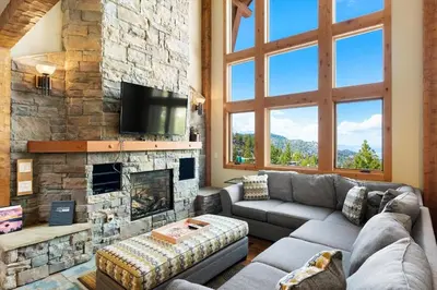 a living room with a couch and a stone fireplace at Stage Coach Run home in Stateline