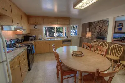 a kitchen with a wooden table and a table and chairs at Foothill Folly home in Zephyr Cove