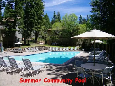a pool with chairs and a table and an umbrella at Spiral Staircase home in Kings Beach