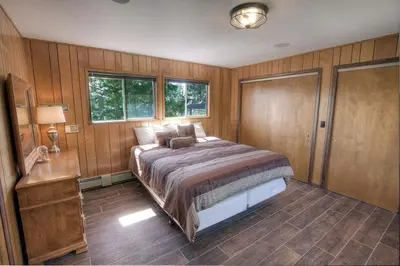a bedroom with a large bed and wooden walls at The Heights home in Zephyr Cove