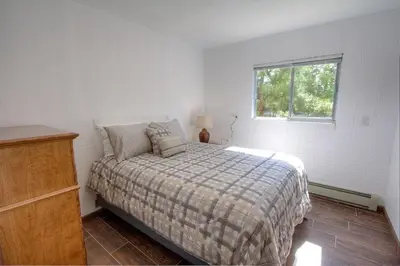 a white bedroom with a bed and a window at The Heights home in Zephyr Cove