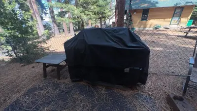 a black tent sitting next to a bench at Smokey Joes cabin in Zephyr Cove