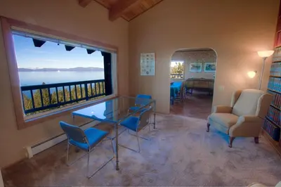 a room with a glass table and chairs and a large window at Lake View Glen home in Lincoln Park
