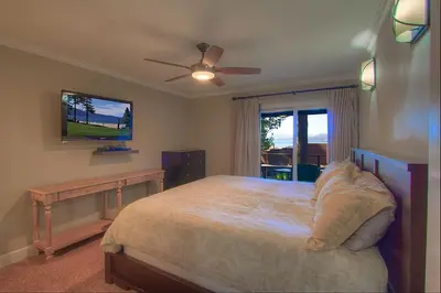 a bedroom with a bed and a flat screen tv at Chipmunk's Paradise condo in Kings Beach