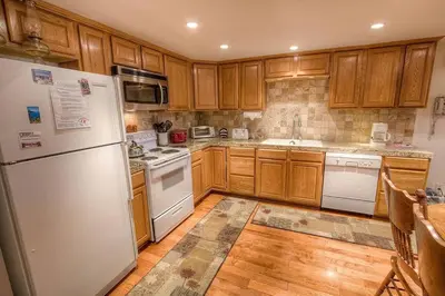 a kitchen with wooden cabinets and a white refrigerator at Eagle's Lake Retreat condo in Incline Village
