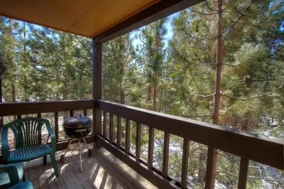 a screened in porch with a grill and a chair at Alpine Getaway home in Tahoe City