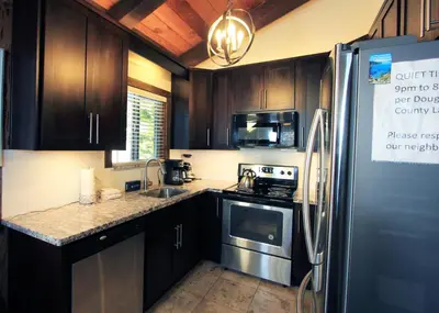 a kitchen with wooden cabinets and a stainless steel refrigerator at Tahoe Olympic condo in Stateline