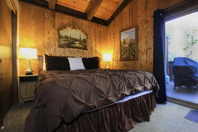 a bedroom with a bed in a room with wooden walls at Tahoe Olympic condo in Stateline