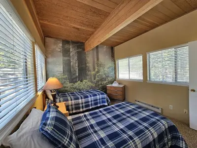 two beds in a room with two windows at Tall Pines Retreat condo in Incline Village