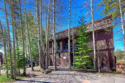a house in the woods with a driveway at Park View Paradise condo in Tahoe City