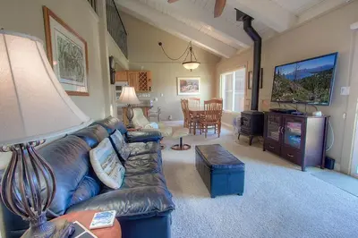 a living room with a leather couch and a tv at Park View Paradise condo in Tahoe City