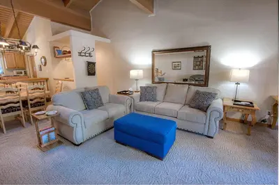 a living room with two couches and a mirror at Whispering Wood home in Incline Village