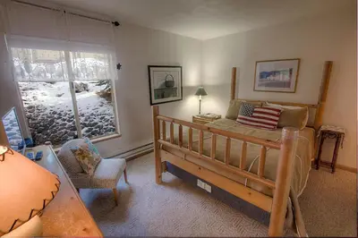 a bedroom with a bed and a window and a couch at Whispering Wood home in Incline Village