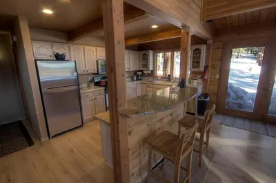 a kitchen with white cabinets and a stainless steel refrigerator at The Bass Chalet home in Kings Beach