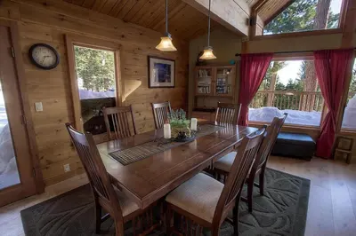 a dining room with a large wooden table and chairs at The Bass Chalet home in Kings Beach