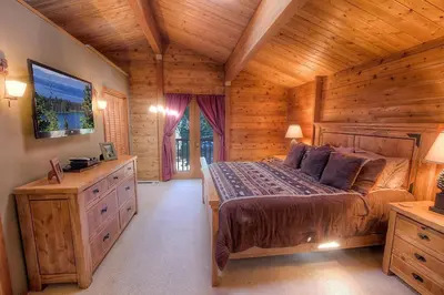 a bedroom with a large bed in a log cabin at The Bass Chalet home in Kings Beach
