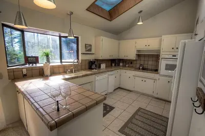 a large kitchen with white cabinets and a counter top at Blue Laulea home in Incline Village