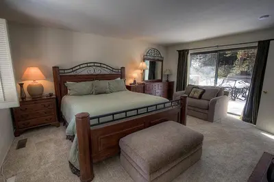 a bedroom with a bed and a chair and a window at Blue Laulea home in Incline Village