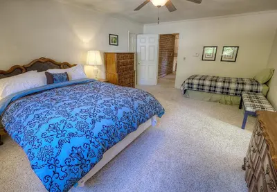 a bedroom with a blue bed and a couch at Cheyenne Chalet home in Round Hill