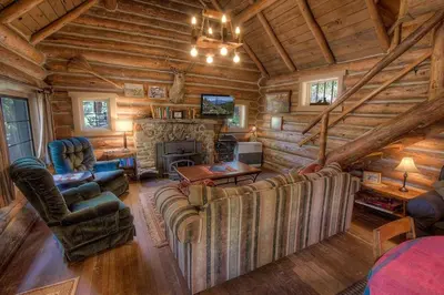 a living room with a couch and a fireplace in a log cabin at Zephyr Cabin home in Zephyr Cove