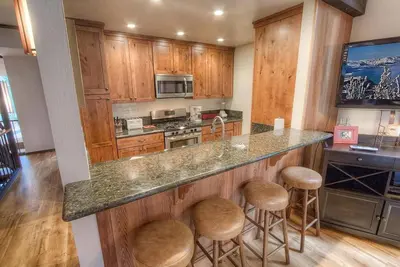 a kitchen with wooden cabinets and a large island with stools at Kingswood Cornerview home in Kings Beach