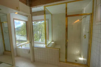 a bathroom with a glass shower and a window at Tumbleweed Pines home in Incline Village