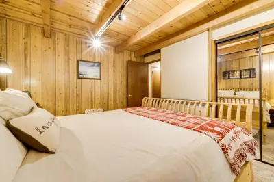 a bedroom with a bed in a room with wooden walls at 6 Mi to Sugar Bowl Resort Soda Springs Cabin! in Soda Springs