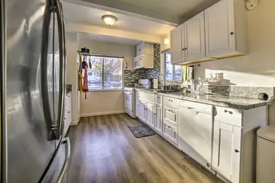 a kitchen with white cabinets and a stainless steel refrigerator at Gateway to Mt Rose Ski! Reno Home with Fireplace in Reno
