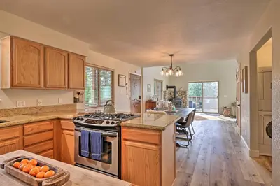 a large kitchen with wooden cabinets and a counter top at Near Hiking and Wineries Arnold Cabin with Deck! in Arnold