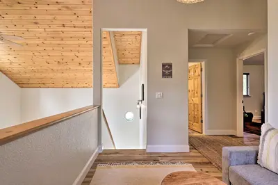a living room with a staircase and wooden ceilings at Near Hiking and Wineries Arnold Cabin with Deck! in Arnold