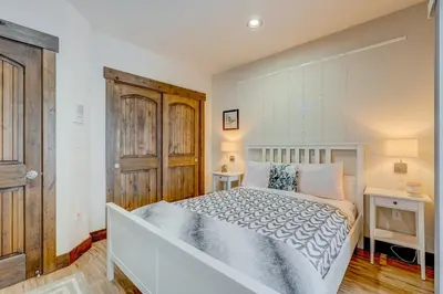 a bedroom with a white bed and a wooden door at Windsor Lodge in Truckee