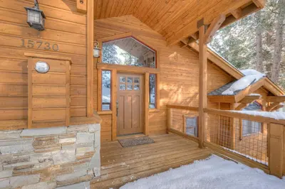 a log cabin with a front door in the snow at Windsor Lodge in Truckee