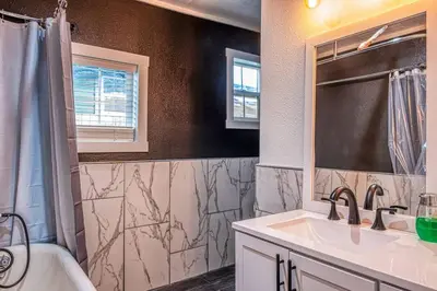 a bathroom with a sink and a shower and a tub at 4BR Victorian Walk to UC Davis & Shriner Med Cen in Sacramento